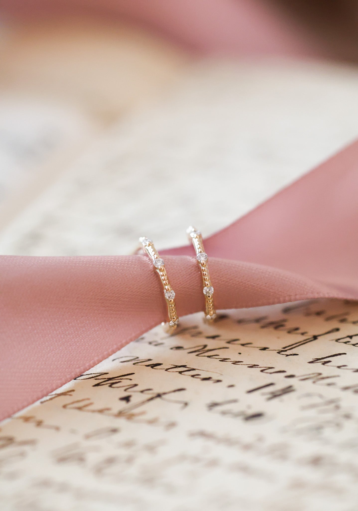 Sirot kultaiset korvarenkaat, joissa kuusi pientä timanttia ja hienovarainen kuviointi